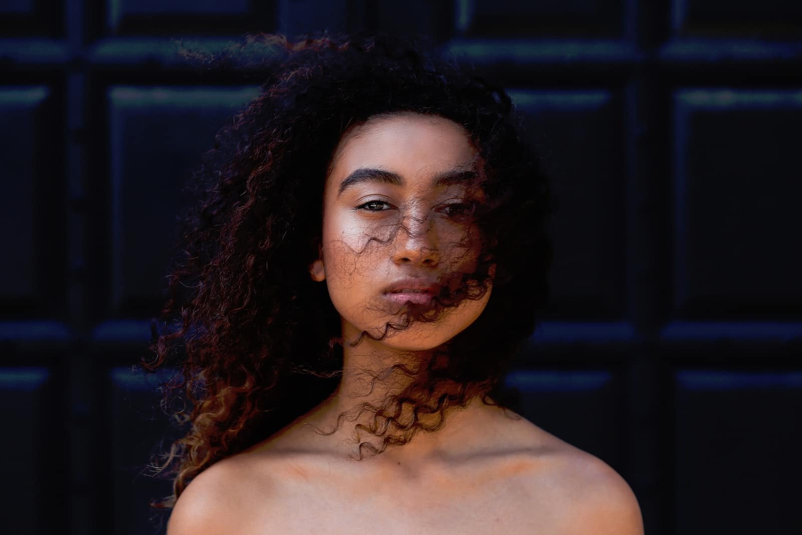 Gros plan sur des boucles brillantes et définies après application d’une gelée coiffante